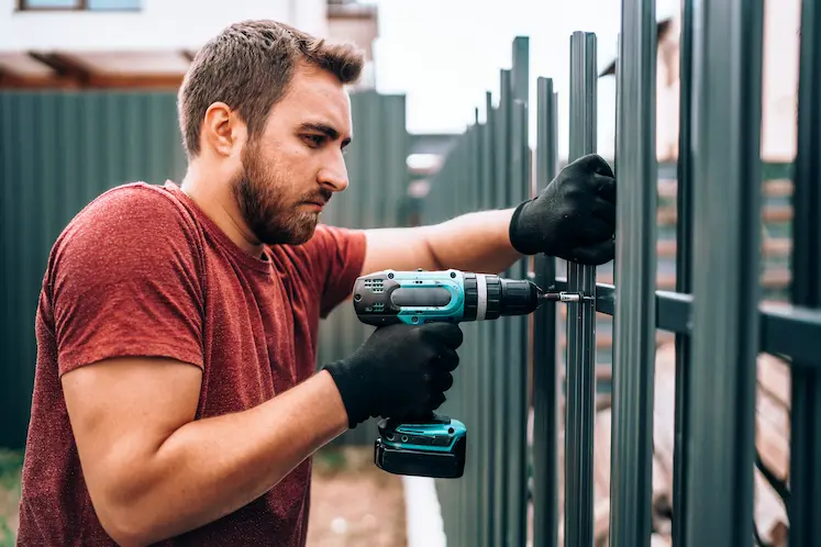 Fabbro al lavoro su riparazione cancello